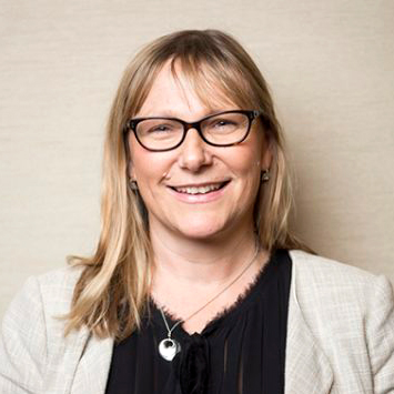 woman wearing glasses and a black blouse.