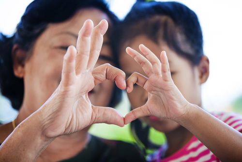 mother and child making a heart handsign