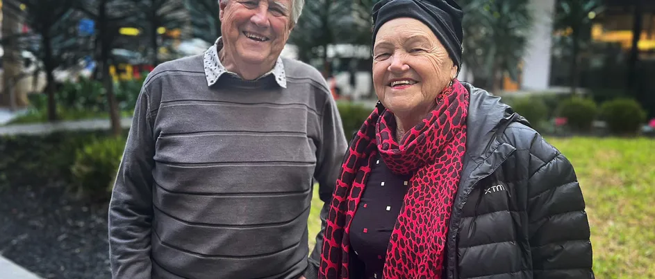 Ross and Marianne Allan, a husband and wife, standing side by side smiling.