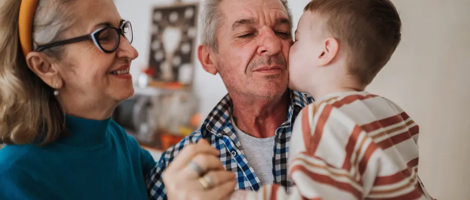 Grandparents hugging their grandchild