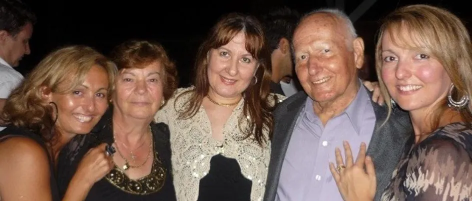 Arthur next to his wife and three daughters, smiling.
