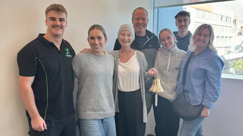 Danielle and her loved lones ringing the bell at the end of her pancreatic cancer chemo
