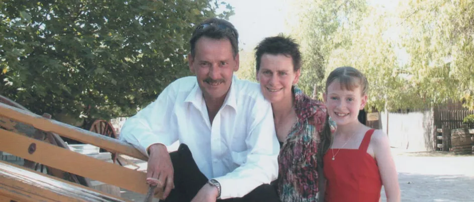 Brian crouching down next to his wife and daughter.