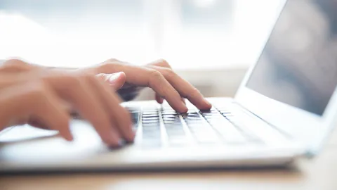 Hands Typing On Laptop Keyboard